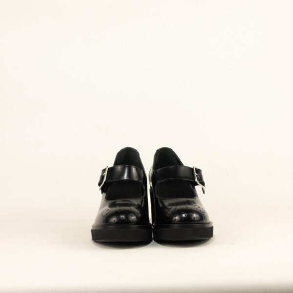 Loafer mocassino baby nero su sfondo roca chiaro