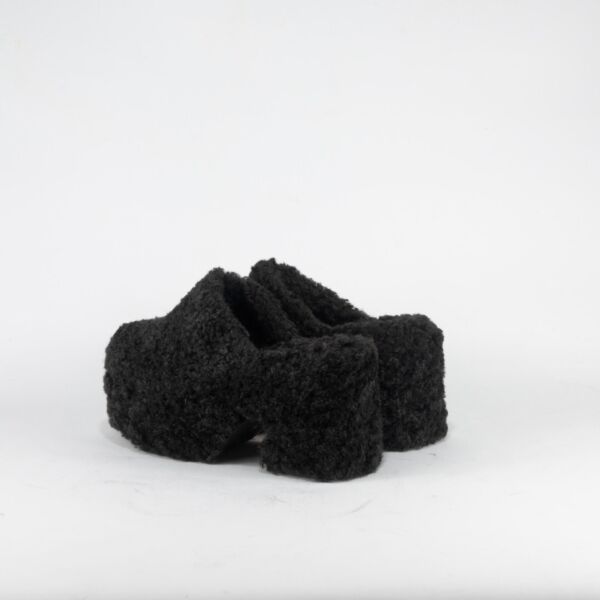 zoccolo sabot in pelo nero con tacco e plateau su sfondo neutro