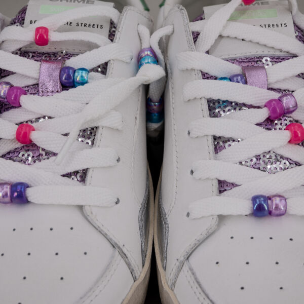 Crime London sk8 charms, in vera pelle colore bianco con dettagli laminato argento, paillettes lilla e lacci con perline.