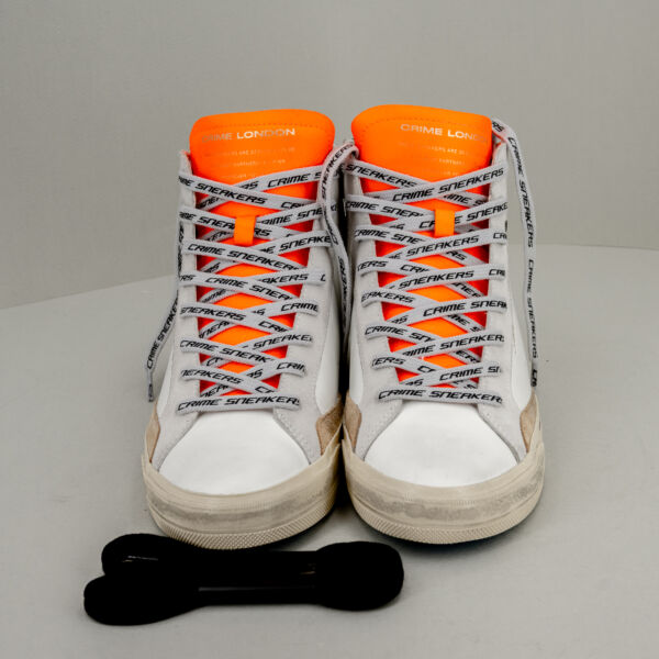 Crime London distressed alta bianca, tipo basket, suola effetto used e linguetta arancio fluo. Stefano Ascari Spilamberto (Mo). Scarpa sportiva fotografata di fronte.