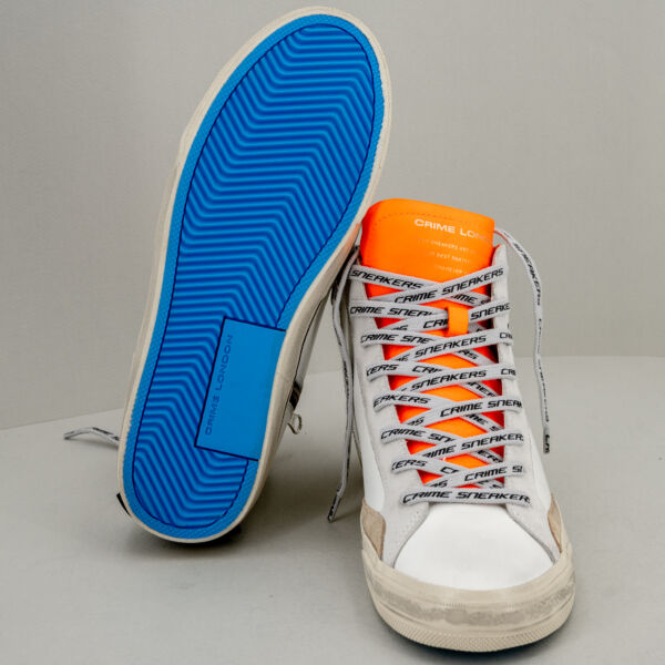 Crime London distressed alta bianca, tipo basket, suola effetto used e linguetta arancio fluo. Stefano Ascari Spilamberto (Mo). Scarpa sportiva fotografata di fronte. e dettaglio suola blu