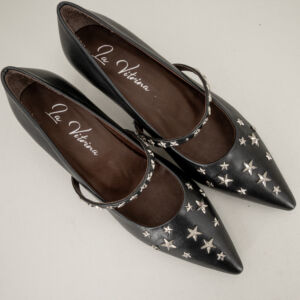 Decolleté pelle nera con cinturino e stelle, in vera pelle molto comoda ed elegante. Fatta in Italia. Stefano Ascari Spilamberto (Mo). Scarpa donna fotografata dall alto sfondo neutro